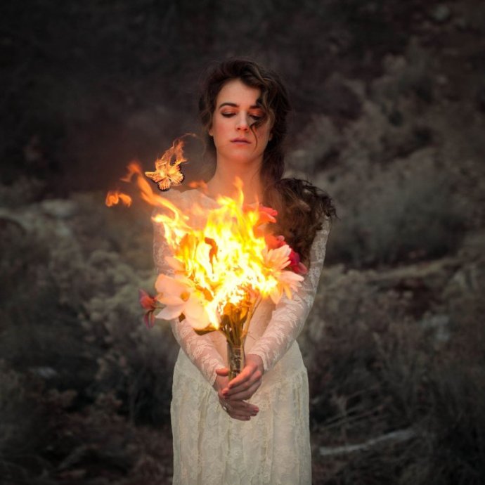 Очаровательная женщина с огнем в руках на фото