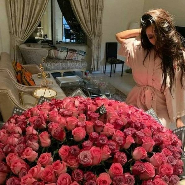 Очаровательная женщина с огромным букетом роз на фото