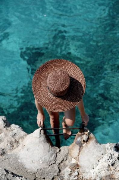 Очаровательная женщина в шапке у моря на фото