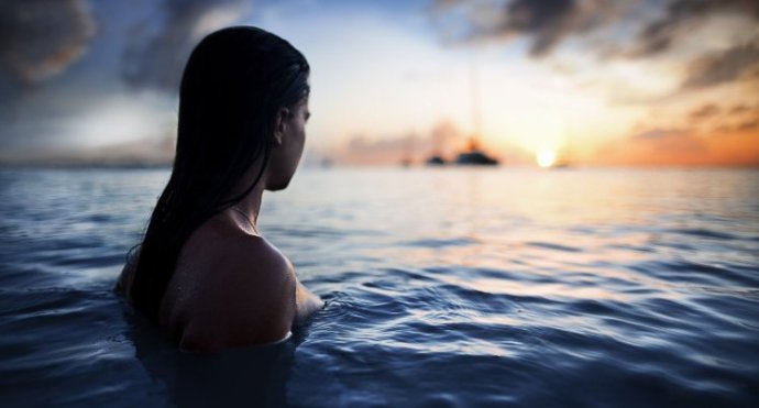 Очаровательная женщина входящая в воду на фото