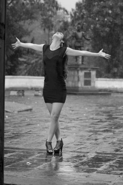 Танцующая очаровательная женщина под дождиком на фото